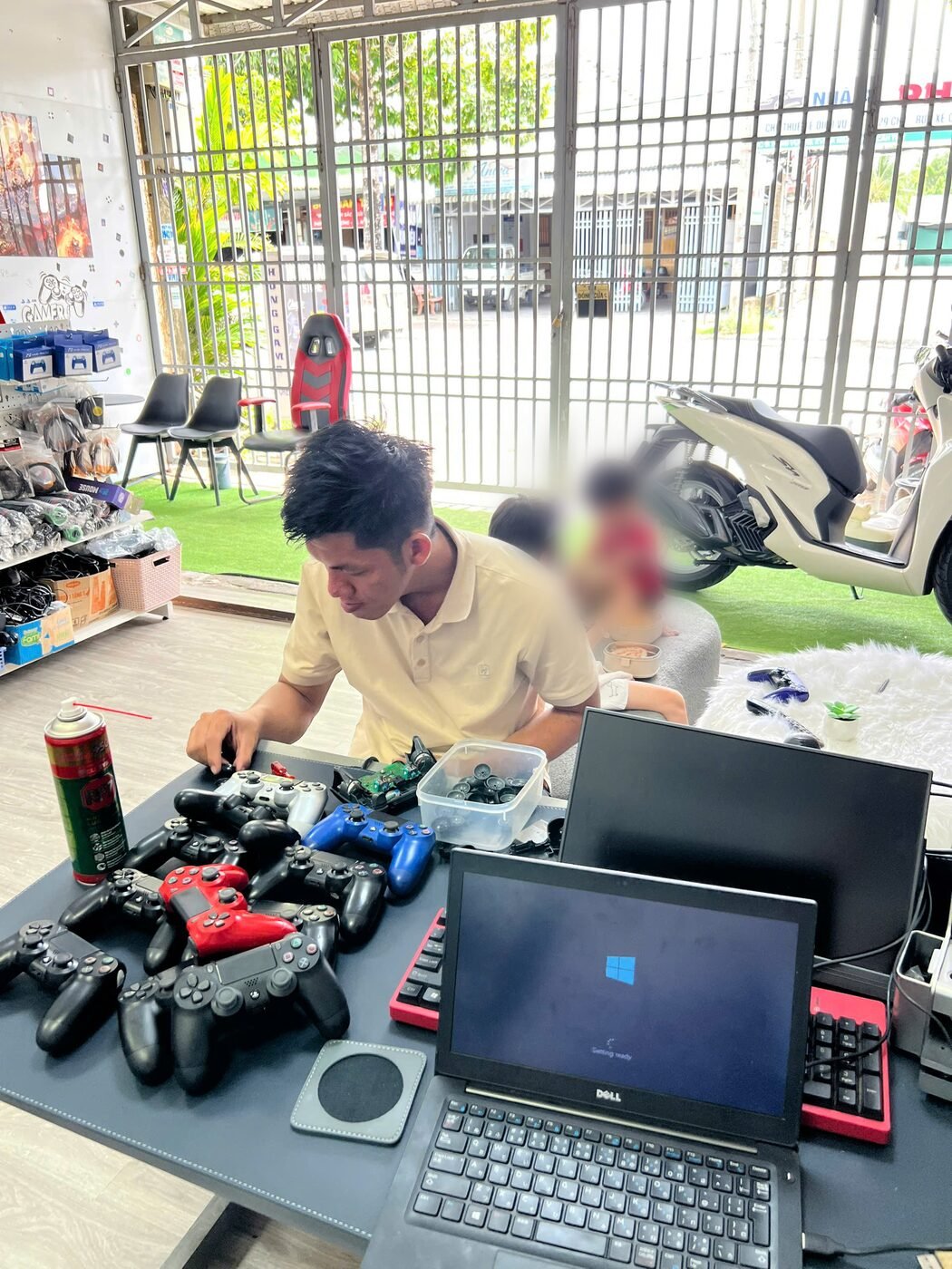 Kỹ thuật viên Hóng Game Store đang sửa tay cầm PS4 tại cửa hàng ở Ngã Bảy, Cần Thơ