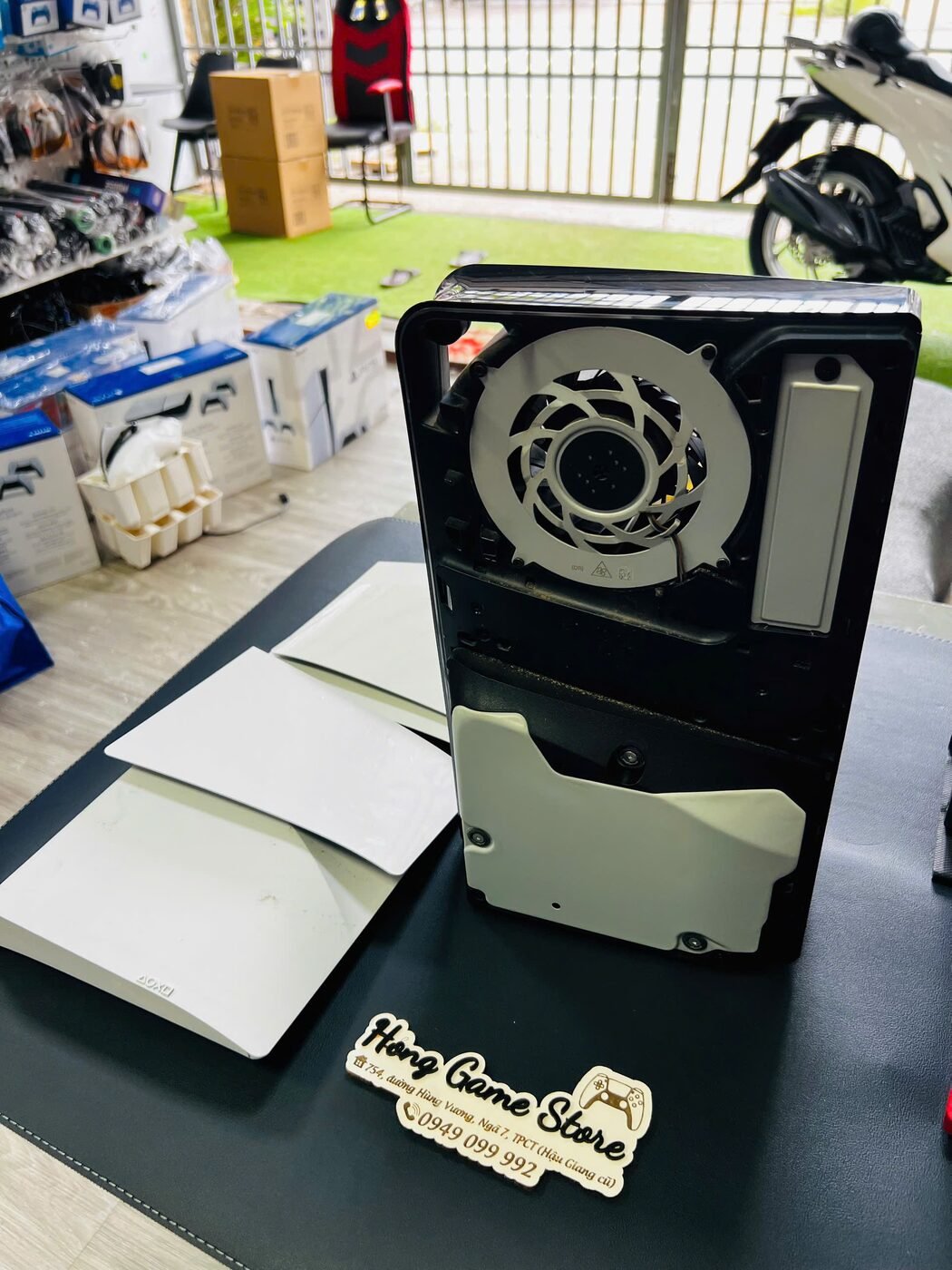 Máy PS5 được tháo hai mặt vỏ để lộ quạt tản nhiệt, chuẩn bị vệ sinh tại Hóng Game Store