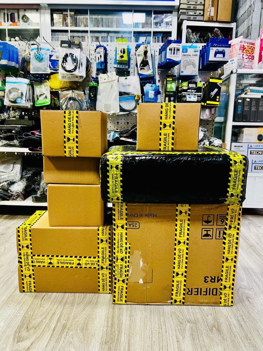 Các thùng hàng dán băng keo chống vỡ, đóng gói tại Hóng Game Store